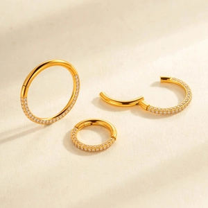 G23 titanium golden nose rings with shimmering zircon inlay set on soft fabric