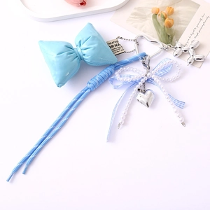 Detail view of light blue nylon braided cord with faux pearls and leather bow keychain