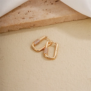 Detail of gold rectangular geometric hoop earrings with zircon micro-pave on silk texture