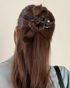 Detail showing high-quality durable dark hair claw clip worn on a woman's bun