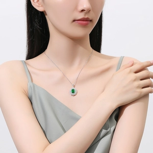 S925 sterling silver flower necklace with emerald green gemstone on a female model