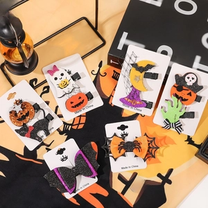 Close-up of Halloween glitter hair clips including pumpkin, ghost, and bat on cards