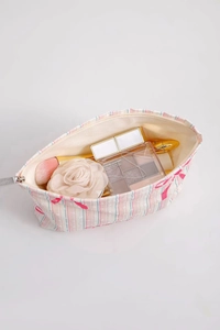 Detail view of pink striped canvas makeup bag showing interior storage capacity and lining