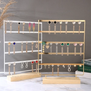 Golden multi-tier metal earring display stand with wooden base for jewelry storage
