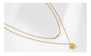 Close-up of double-layer gold necklace with hammered irregular round pendant on white background