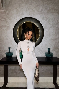 Détail d'une robe blanche à manches longues avec décoration de rose ajourée sur la poitrine