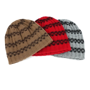 Detailed knit texture of striped beanie hats in brown, red and grey for winter warmth