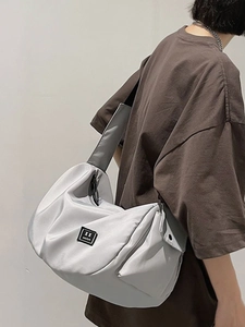 Large silver gym bag in shiny synthetic fabric shown on model for travel and fitness