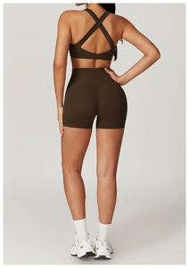 Vista posteriore del reggiseno sportivo marrone scuro con incrocio e pantaloncini fitness