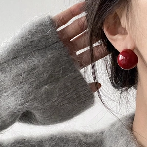 Elegant cherry red glazed ball stud earrings for women shown on a model profile view