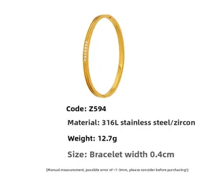 Macro detail of 316L stainless steel gold bangle with 5A cubic zirconia and geometric grooves