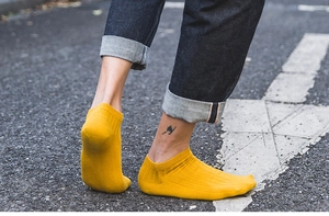 Outdoor street style shot of mustard yellow cotton ankle socks with ribbed cuffs on model
