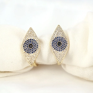 Exquisite gold evil eye earrings with blue and white zircon pavé on textured fabric