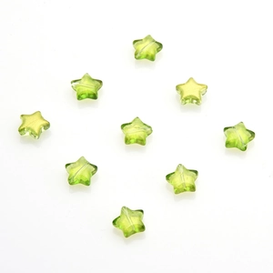 Macro view of green star crystal pendants with gold glitter for DIY jewelry making