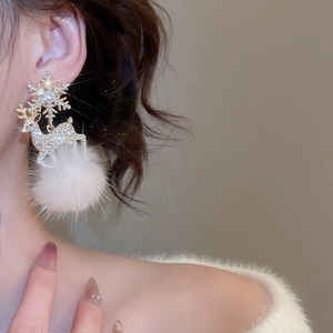 Detail of Christmas reindeer earring with snowflake, rhinestones and white fur ball