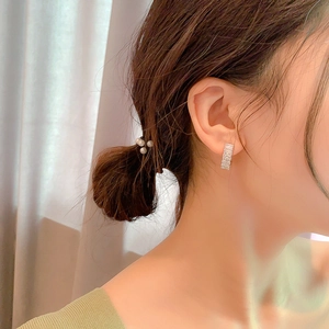 Close-up of elegant silver huggie earrings with baguette-cut sparkling crystals