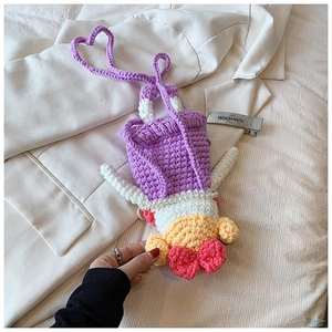 Close-up of handmade crochet sausage mouth girl bag with pearl necklace detail