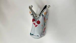 Detail view of mini Christmas canvas coin purse with silver metal clasp and festive pattern