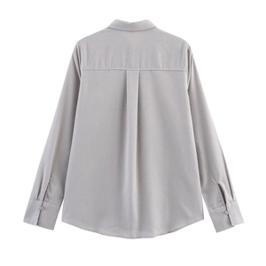 Detail view of the back of a light grey linen shirt featuring back pleats and long sleeves