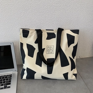Detail of canvas tote bag with black geometric print and Good Student rabbit graphic