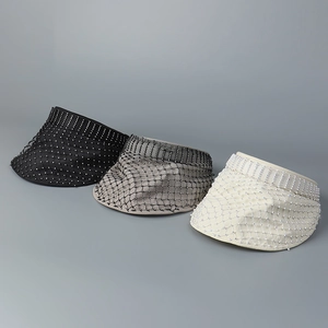 Detail view of mesh sun visors with rhinestones and pearls in black, grey, and cream