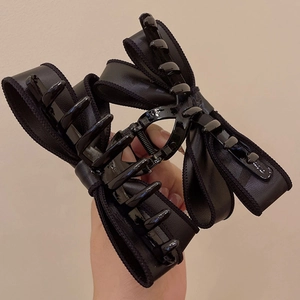 Detailed view of large black satin bow claw clip showing its sturdy resin teeth and size