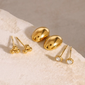 Detailed macro view of three pairs of 18k gold plated stainless steel zircon stud earrings