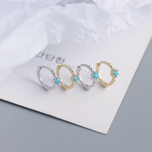 Detail of gold and silver S925 sterling silver huggie hoops with turquoise beads