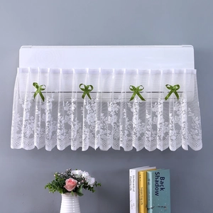 Detail of white lace air conditioner cover with decorative green silk ribbon bows