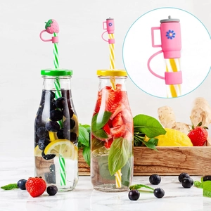 Detail of pink strawberry and flower silicone straw covers on reusable glass bottles