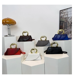 Group shot of colorful crocodile pattern handbags with unique C-shaped gold metal handles