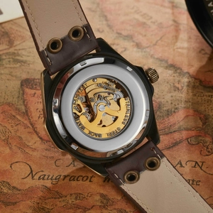Macro view of skeleton mechanical watch with transparent back showing golden movement gear