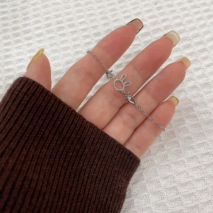 Detailed view of silver rabbit and carrot charms on a delicate bracelet for women