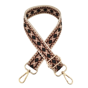 Detail of bohemian geometric diamond pattern shoulder strap with gold metal hooks