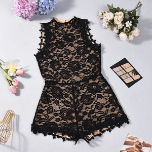Detailed view of black lace sleeveless romper with beige lining and floral decor