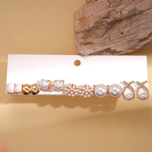 Detail view of 6-pair stud earring set with pearls and diamonds on a white card display