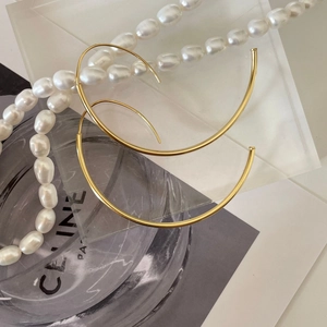Minimalist large golden C-shaped hoop earrings with a polished finish for women