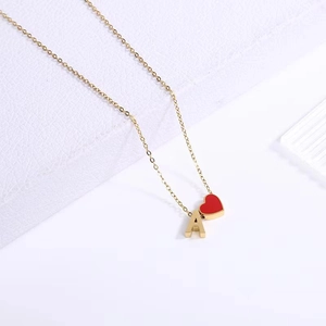 Minimalist gold stainless steel letter A necklace with a small red enamel heart pendant