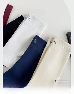 Detail of ribbed cuffs and letter embroidery on multi-color cotton crew socks