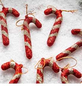 Detail of red and gold glitter Christmas candy cane ornaments with hanging strings