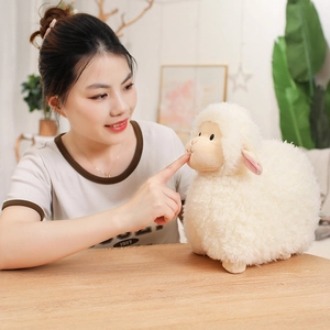 Cute white plush sheep toy with curly faux wool and realistic texture on a wooden table