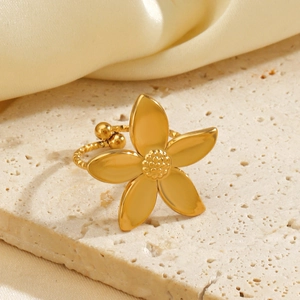 Golden flower ring with five-petal design and twisted band on a stone platform