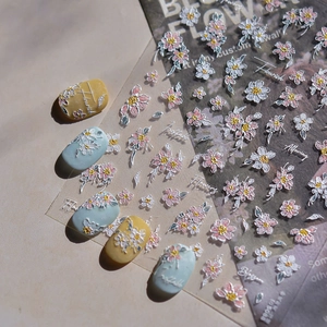 Macro view of 3D embossed floral nail stickers with pink cosmos and script lettering