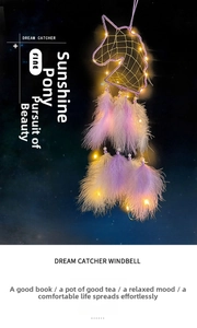 Detail of purple unicorn dream catcher with warm LED lights and delicate feathers