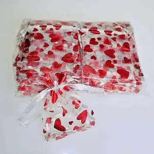 White organza gift bag with red heart pattern and satin drawstring for Valentines Day