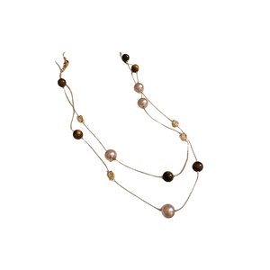 Brown layered necklace with pink pearls, tiger eye beads and gold hollow spacers on white background