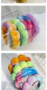 Close-up of braided tie-dye velvet headbands with sponge filling in a white metal basket