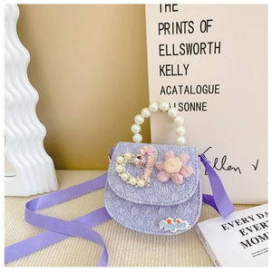 Detail of purple embossed girls' crossbody bag with pearl handle and knitted flower