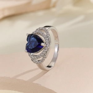 Elegant silver ring with heart-shaped blue gemstone and micro-pave zircon halo