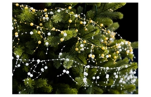 Close-up of white and gold bead garland strands hanging on a green Christmas tree